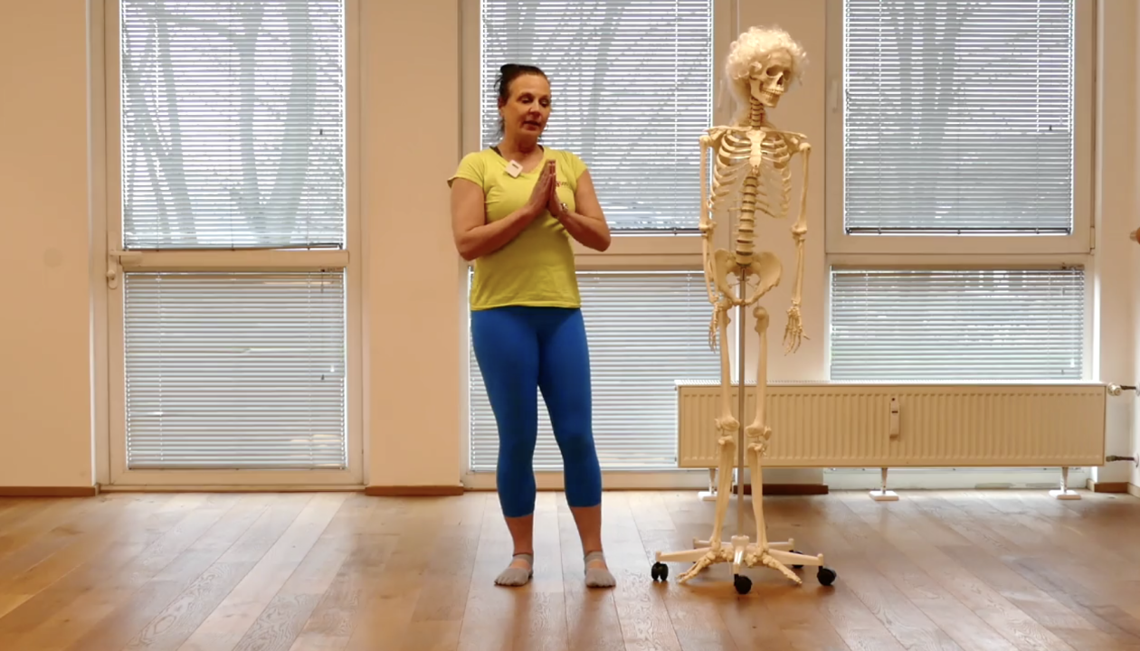 Natascha Eybert steht neben einem Skelett und erklärt, die Hände sind vor ihrer Brust.
