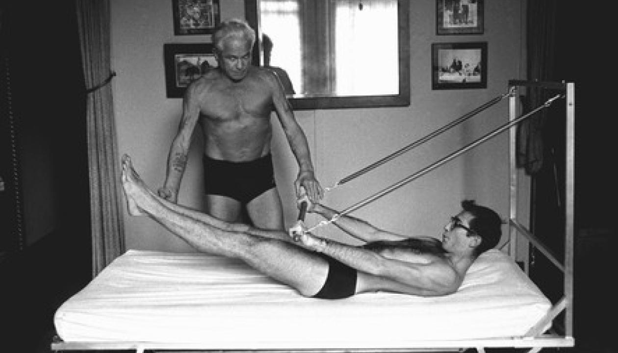Ein Originalbild von Joseph Pilates, der einen Patienten trainiert