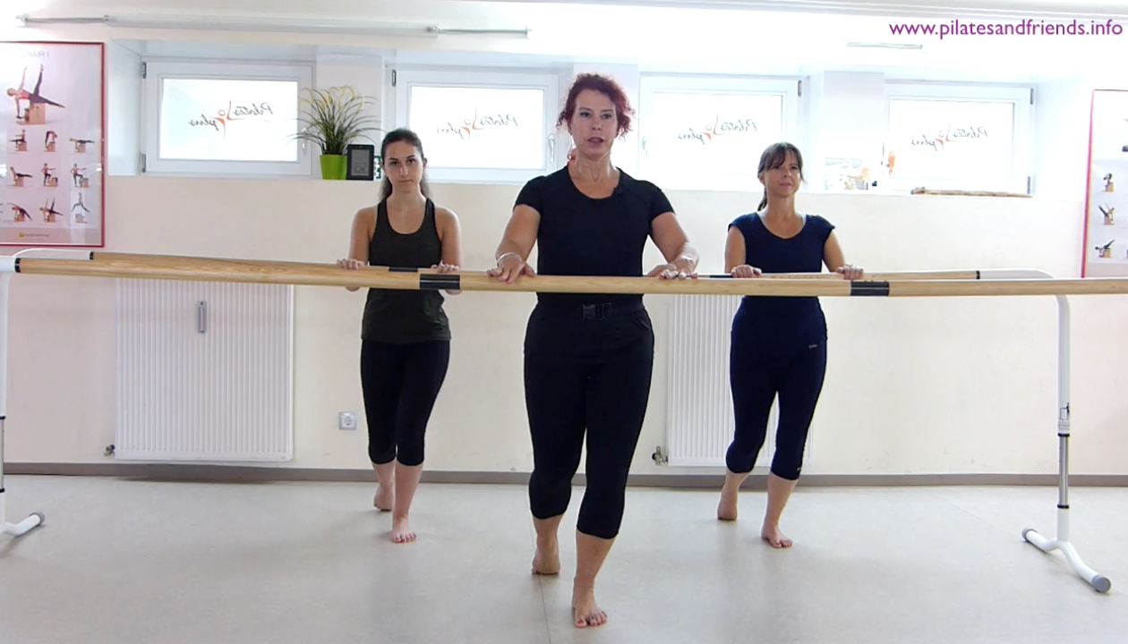 Silvia Guidi de Knappe steht mit zwei weiteren  Personen an einer Ballettstange, ein Bein steht zurück auf der Oberseite der Fußzehen